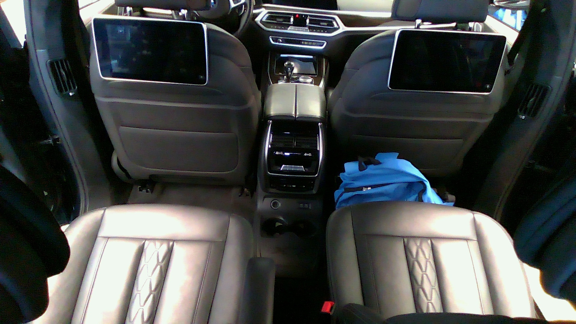Original frame — blue jacket on the rear seat of a BMW iX cabin.