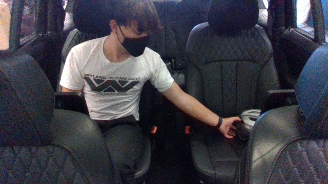 An actual RealSense D435 frame captured inside the test vehicle &mdash; a person in the rear seat reaching across to the next seat.